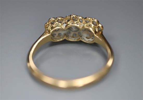 An 18ct yellow and white gold diamond triple cluster ring, size L/M, gross 2.7g